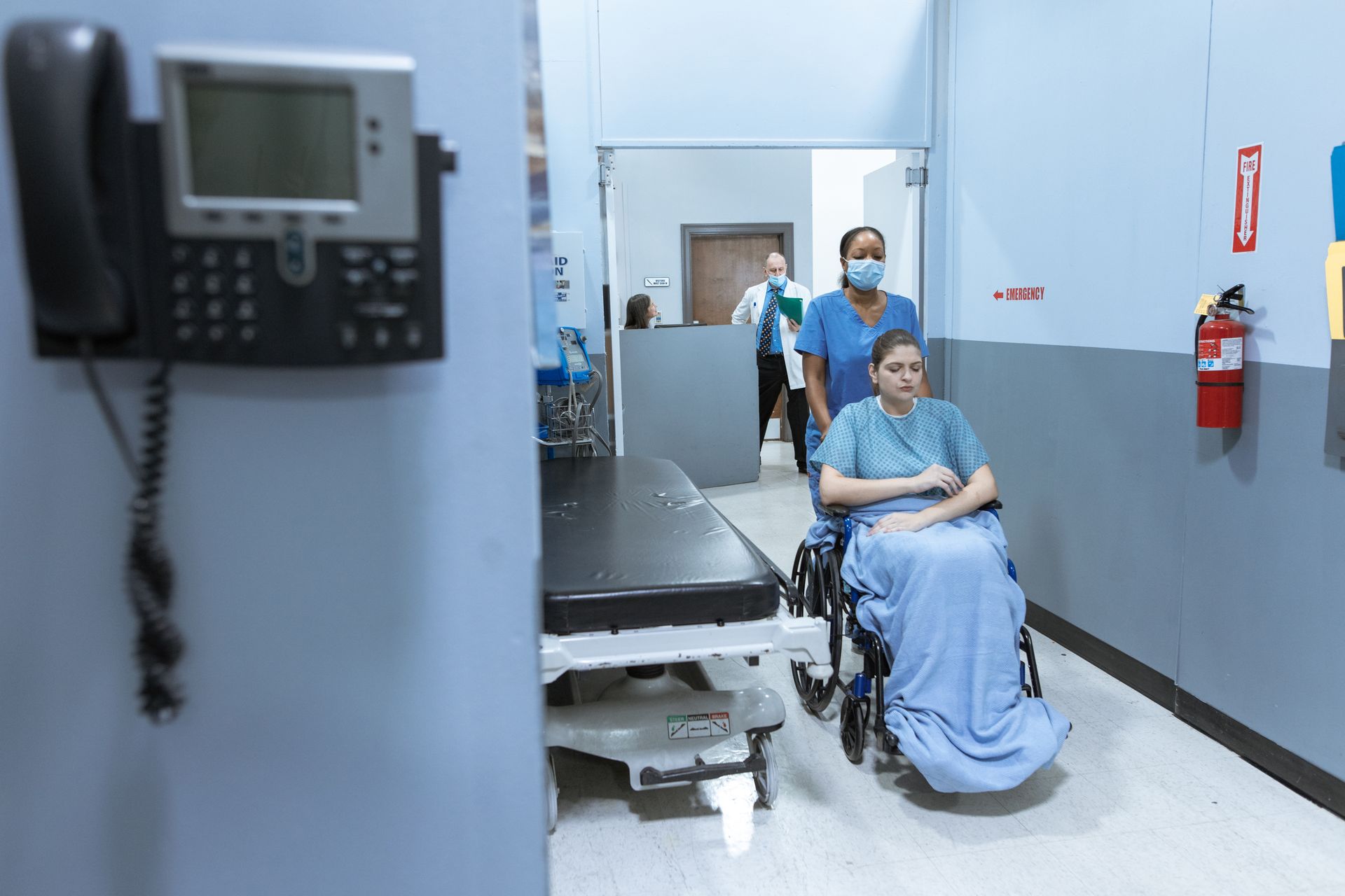 Medical worker pushing a patient in a wheelchair.