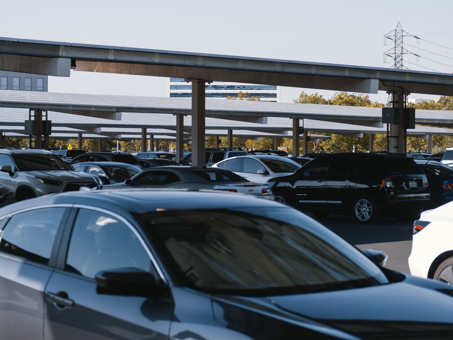 Cars parked under canopies with solar panels in an urban area